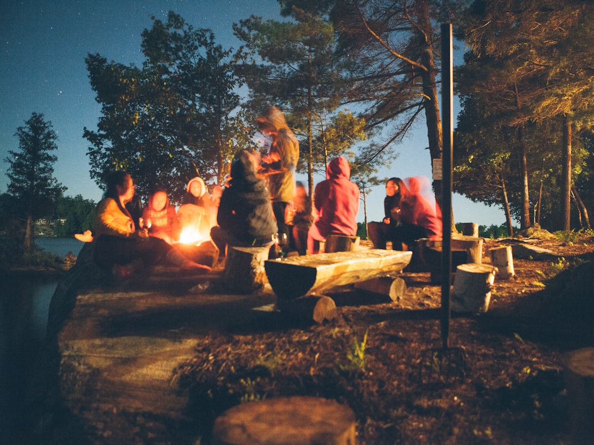 A group sitting around a campfire at dusk